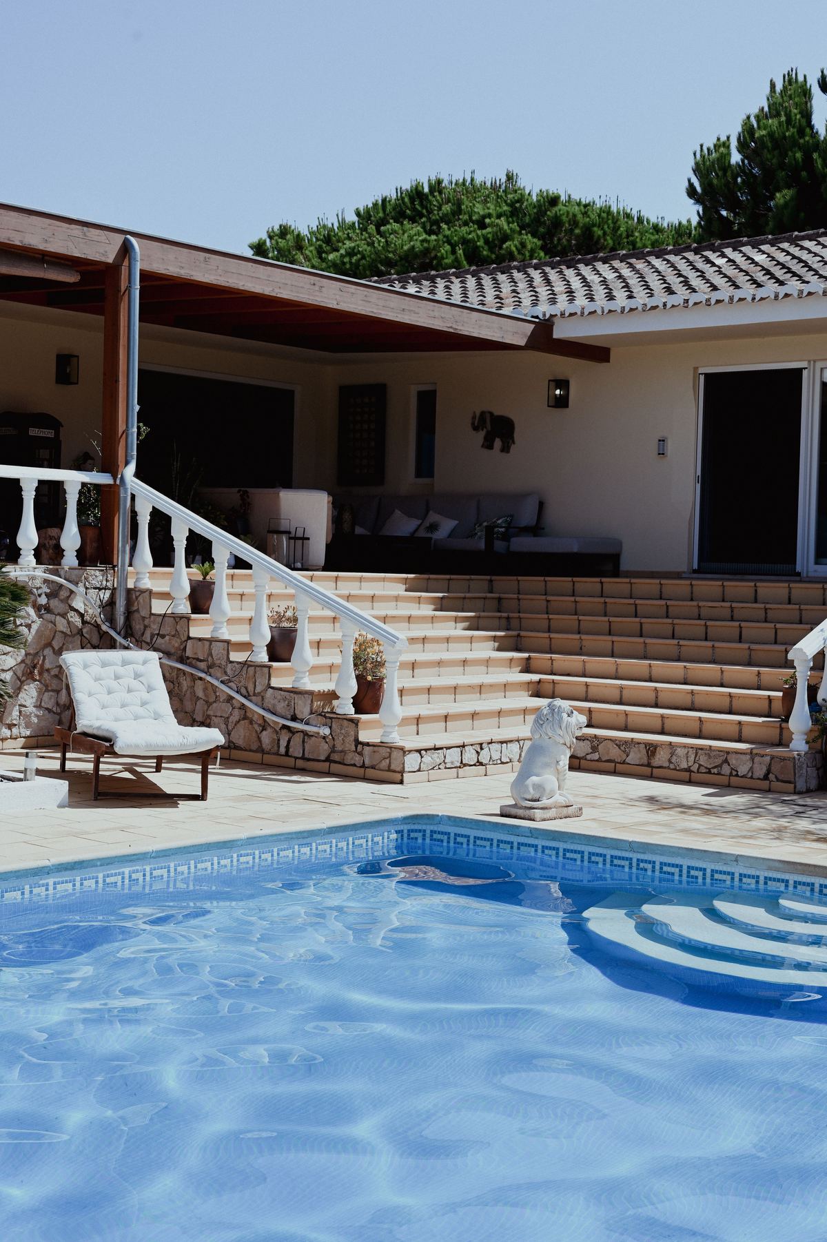 Piscina residencial con baldosas en muros y área recreativa